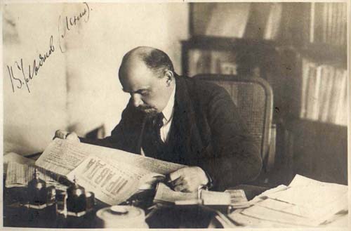 Lenin reads Pravda newspaper at his study desk at his flat in the Kremlin. October 16, 1918.