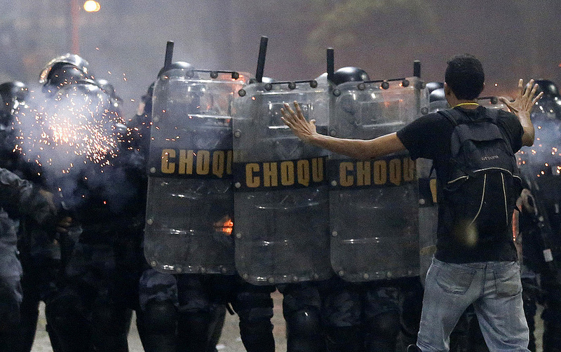 A demonstrator tries to stop the riot police during one of many protests around Brazil’s major cities in Rio de Janeiro June 20, 2013. Tens of thousands of demonstrators marched through the streets of Brazil’s biggest cities on Thursday in a growing protest that is tapping into widespread anger at poor public services, police violence and government corruption. REUTERS/Sergio Moraes