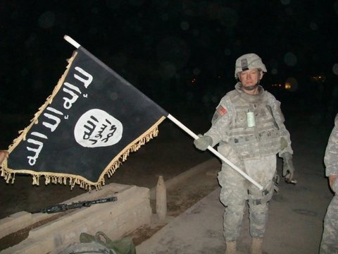 US Soldier holding a captured Islamic State flag. 2010. (US Army, Wikipedia Commons)