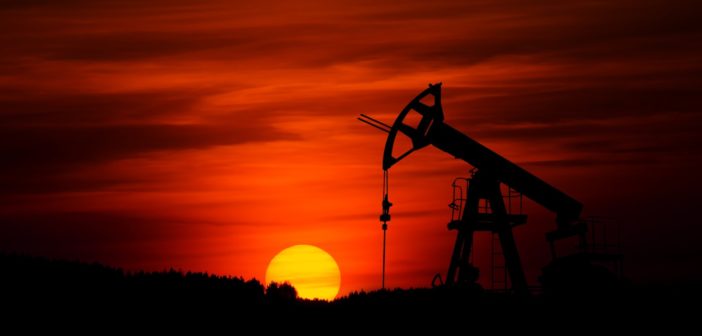 Pump-jack mining crude oil with the sunset,